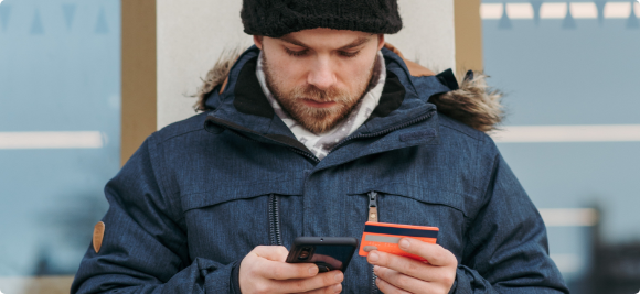 man looking up credit card information on his phone