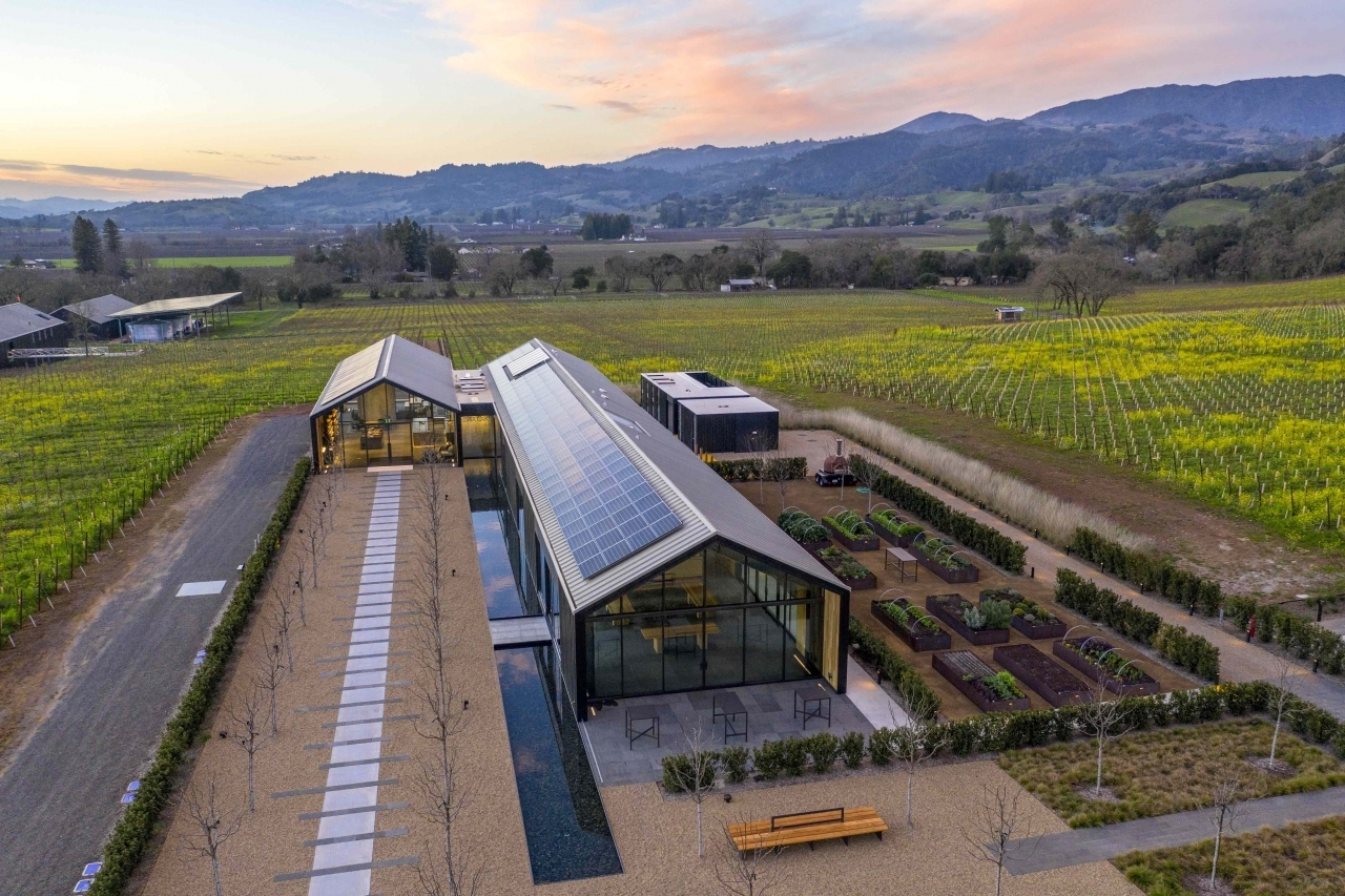Silver Oak Winery shown from an aerial shot. Vineyards, gardens, and solar panels on the roof are visible in the photo