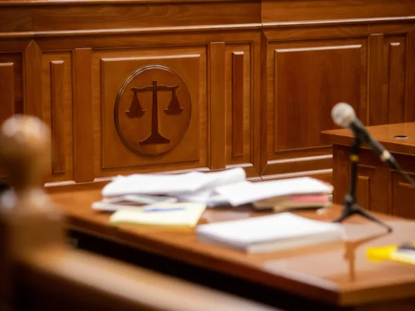 A desk inside a courtroom with papers and a microphone