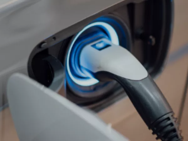 Close-up of a white electric car plugged in and charging