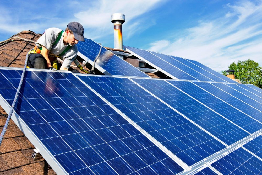 Man installs solar panels on a roof
