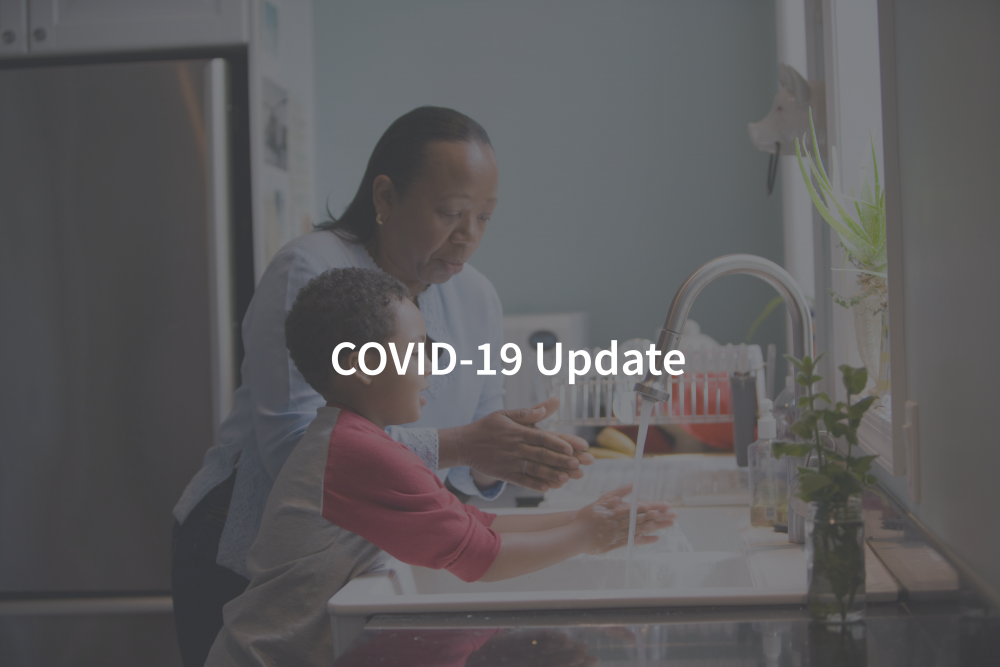A woman and her child wash their hands, with the words "COVID-19" on top